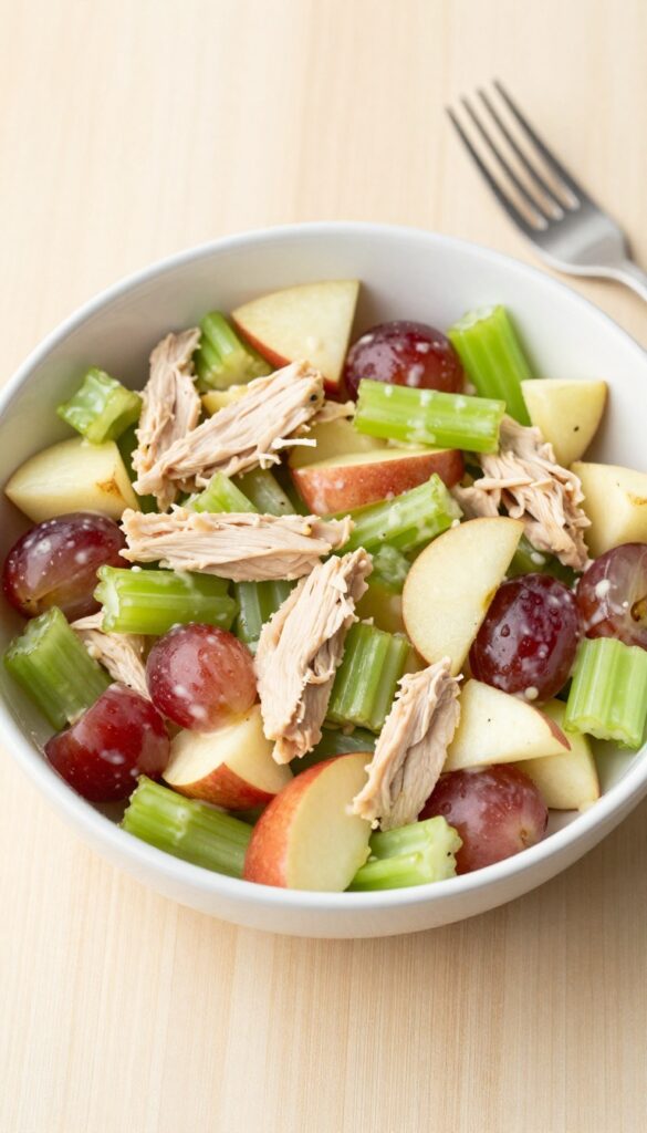 Bowl of grape and celery crunch apple chicken salad on a wooden table