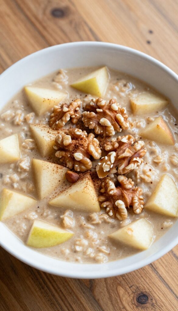 A bowl of apple cinnamon oatmeal topped with chopped walnuts, natural lighting.