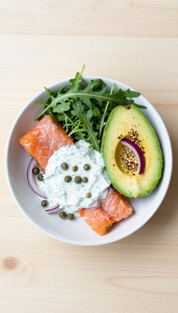 Smoked salmon and avocado breakfast bowl with arugula and dill yogurt dressing