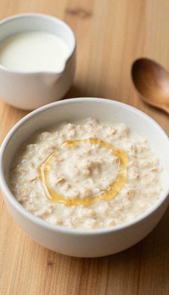 Bowl of creamy porridge with golden syrup drizzle on a wooden table